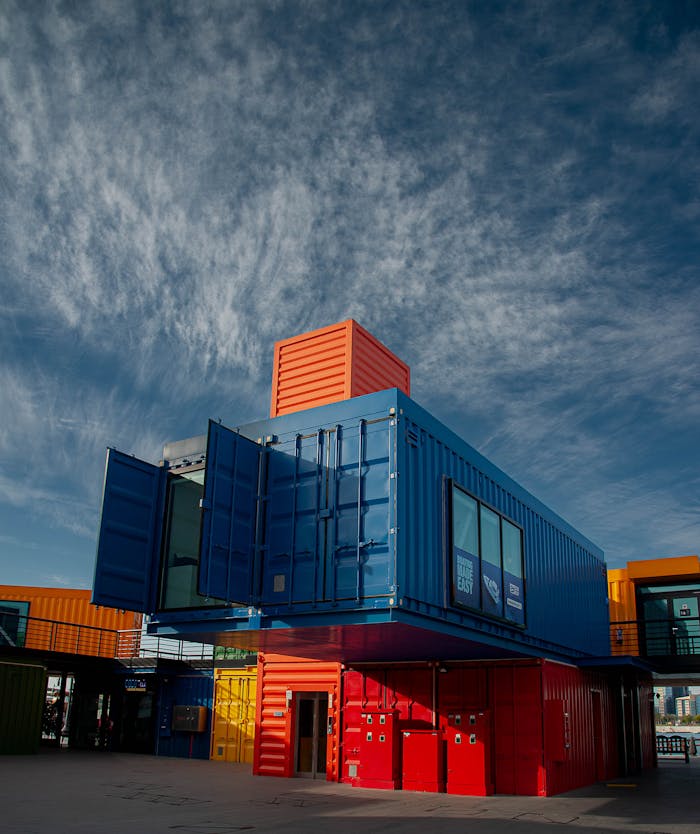 services-02 Vibrant shipping containers arranged creatively under a bright sky, showcasing modern architectural innovation.